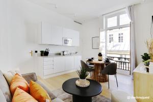 ein weißes Wohnzimmer mit einem Sofa und einem Tisch in der Unterkunft CMG - Place des Vosges / Turenne in Paris