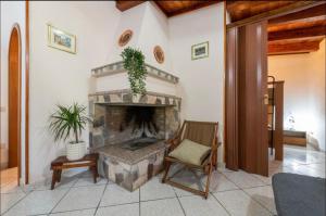 a living room with a fireplace and a chair at Villa Lidia per una vacanza di relax in Solanas