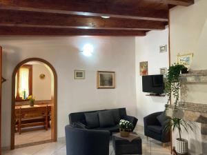 a living room with a couch and a tv at Villa Lidia per una vacanza di relax in Solanas