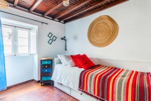 a bedroom with a bed and a straw hat on the wall at Casa das 10 Janelas @ Monsanto in Monsanto