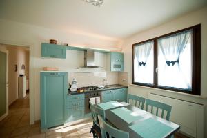 a kitchen with blue cabinets and a table in it at Appartamenti Villa Ancora in Castiglione della Pescaia