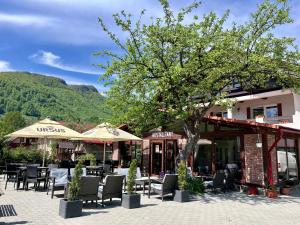 a restaurant with tables and chairs and a tree at Casa Cenţiu in Bran