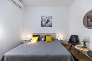 ein Schlafzimmer mit einem großen Bett mit gelben Kissen in der Unterkunft Guest House Anna in Mlini