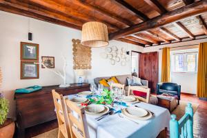 a dining room with a table and a couch at Casa das 10 Janelas @ Monsanto in Monsanto