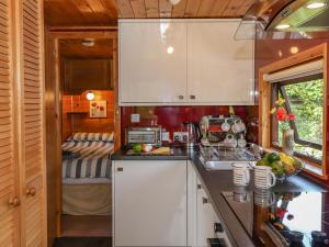 eine Küche mit weißen Schränken und einem Waschbecken in der Unterkunft Robin's Nest in Keswick
