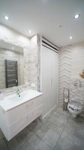 um banheiro com uma pia branca e um vaso sanitário em Apartamenty EverySky - Konstytucji 3 go Maja 66-1 em Karpacz mais 4 fotografias