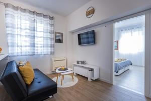 uma sala de estar com um sofá e um quarto em Guest House Anna em Mlini