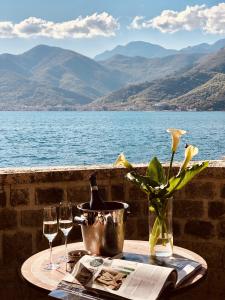 un tavolo con una bottiglia di vino e due bicchieri di Carrubba a Tivat