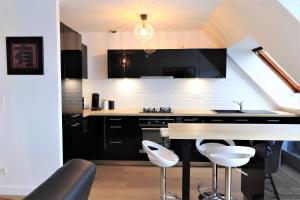 eine Küche mit schwarzen und weißen Geräten und einem Tisch in der Unterkunft LE BONDON in Vannes