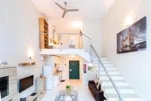 a living room with a staircase and a couch at Oshun Madrid Norte LOFTS & MIDSTAY in Madrid