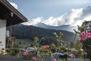 a view of the mountains from a house with flowers at Ferienwohnung Haus Hirschbichl in Berchtesgaden