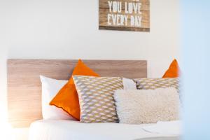 a pile of pillows sitting on top of a bed at Oshun Madrid Norte LOFTS & MIDSTAY in Madrid