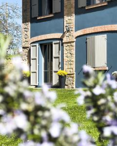 una casa azul con una puerta y flores en el patio en B & B Casolara, en San Giovanni