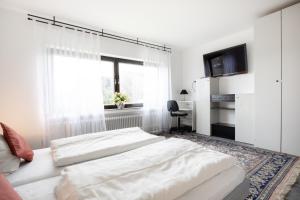 a white bedroom with a bed and a window at Ferienwohnung Wäller Sonnenschein in Westerburg