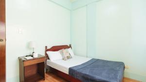 Habitación pequeña con cama y mesita de noche en En Gedi Beach Resort by RedDoorz en Iba