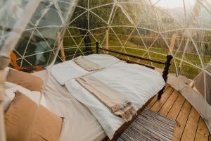 Versam的住宿－Bubble-Suite in Graubünden，木制甲板上圆顶帐篷内的一张床位