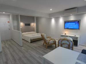 een hotelkamer met een bed en een tv aan de muur bij Bay View Apartments in Albufeira