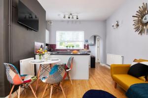 una cucina e un soggiorno con tavolo e sedie di Delven House, Apartment 1 a Castle Donington