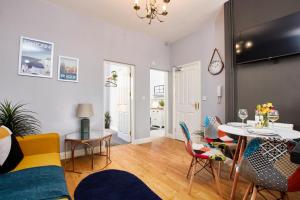 uma sala de estar com mesa e cadeiras em Delven House, Apartment 1 em Castle Donington