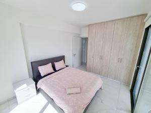 a bedroom with a bed with a pink blanket at Shades Of Blue Apartment in Larnaca