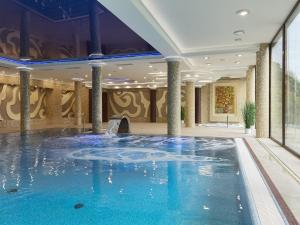 einen Pool in einer Hotellobby mit Pool in der Unterkunft Ośrodek Uzdrowiskowy Świerkowy Zdrój Medical Spa in Rymanów-Zdrój