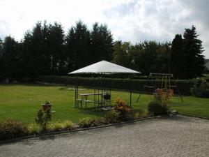einen Park mit einer Schaukel und einem weißen Regenschirm in der Unterkunft Ferienwohnung Kaiser in Reifferscheid