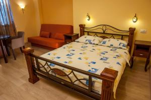 ein Schlafzimmer mit einem Bett, einem Stuhl und einem Sofa in der Unterkunft Hotel Laguna in Podgorica