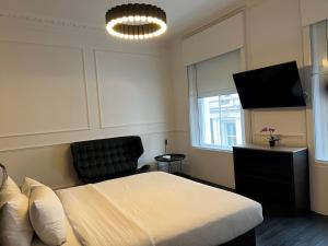 Un dormitorio con una cama y un televisor de pantalla plana. en The Z Hotel Covent Garden, en Londres