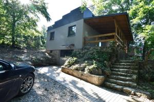 a house with stairs and a car parked in front of it at chata Sivá in Vinné
