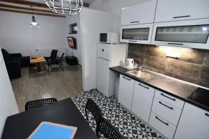 a kitchen with a sink and a table with chairs at chata Sivá in Vinné