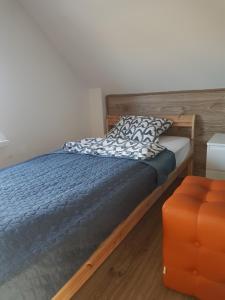 a bedroom with a bed and an orange ottoman at Domki na Wzgórzu Jastrzębia Góra Tupadły in Jastrzębia Góra