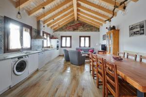 cocina y comedor con mesa y lavadora en Casa A'Pajera, en Orós Alto