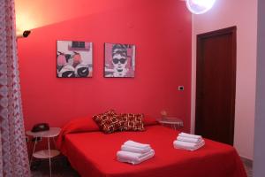 a red room with a bed with a red wall at B&B Dietro l'Angolo in Benevento