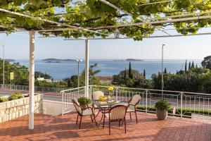 un patio con tavolo, sedie e vista sull'oceano di Guest House Anna a Mlini
