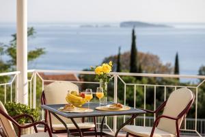 einen Tisch mit Getränken und eine Vase Blumen auf dem Balkon in der Unterkunft Guest House Anna in Mlini