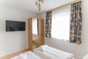 1 Schlafzimmer mit 2 weißen Betten und einem Fenster in der Unterkunft Apartments Oasis Wörthersee neu & zentral in Krumpendorf am Wörthersee