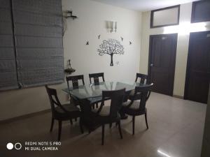 a dining room with a glass table and chairs at Hotel Home Stay Dwarka in New Delhi