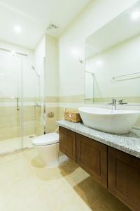 ein Bad mit einem Waschbecken, einem WC und einer Dusche in der Unterkunft My Serenity Service Apartment - West Lake in Hanoi