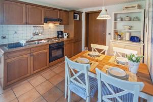 a kitchen with wooden cabinets and a wooden table and chairs at Strandkorb in Neßmersiel