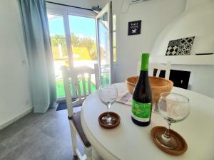 a bottle of wine sitting on a table with two glasses at Apartamento con vistas al Campo de Golf y Piscina in Mijas Costa
