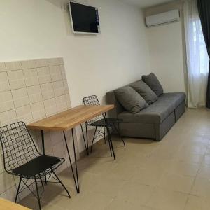 a living room with a couch and a table and chairs at Apartmani Naumovi 2 in Star Dojran