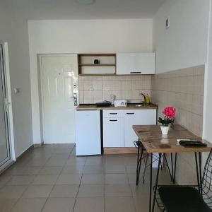 a kitchen with white appliances and a wooden table at Apartmani Naumovi 2 in Star Dojran