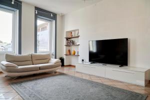 sala de estar con TV grande y sofá en Anna Homestay Bergamo, en Bérgamo