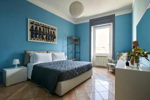 1 dormitorio azul con 1 cama y 1 silla en Anna Homestay Bergamo, en Bérgamo