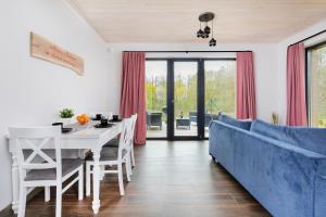un soggiorno con un tavolo e un divano blu di Domki Lubkowo by Renters Prestige a Lubkowo