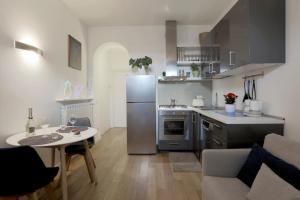 eine Küche mit einem Kühlschrank aus Edelstahl und einem Tisch in der Unterkunft Il Cortile di Milano in Mailand