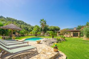 een tuin met stoelen en een zwembad bij Villa Can Brullet by SunVillas Mallorca in Pollença