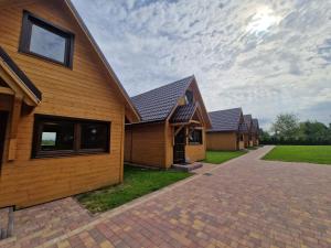 a row of houses on a brick driveway at Domki Harnaś Energylandia in Przeciszów