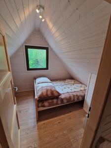 a small room with a bed in a attic at Domki Harnaś Energylandia in Przeciszów