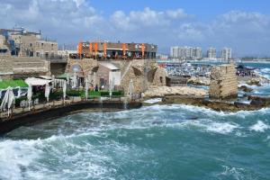 a bridge over a body of water with waves at The German House in ‘Akko